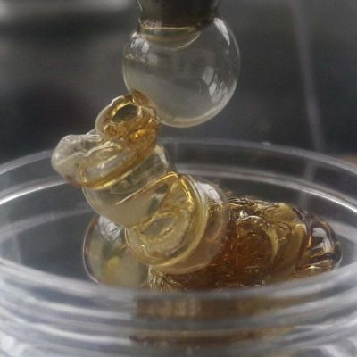 Close-up of pure, solvent-free rosin piling into a container directly from the GEMSTX manual extractor tip.